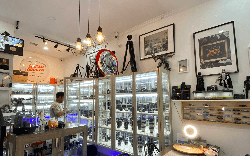 Showroom Garasi Kamera dengan etalase lensa dan perlengkapan kamera